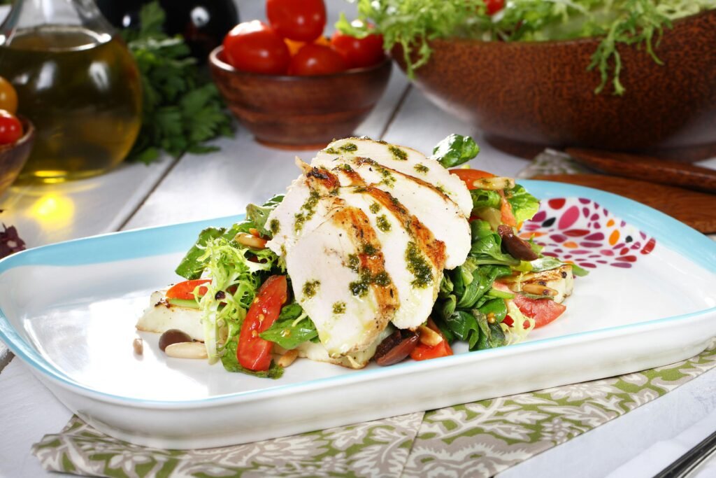 Ingredients for healthy chicken salad including chicken, greens, and balsamic